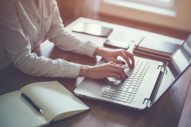 Femme d'affaires dactylographiant sur l'ordinateur portable à la femme de lieu de travail travaillant dans le clavier de main de Femme d'affaires dactylographiant sur l'ordinateur portable à la femme de lieu de travail travaillant dans le clavier de main de