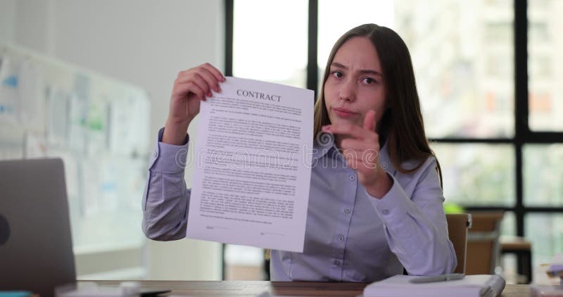 Femme d'affaires détient un contrat en main pointant la main sur les documents contractuels banque de vidéos