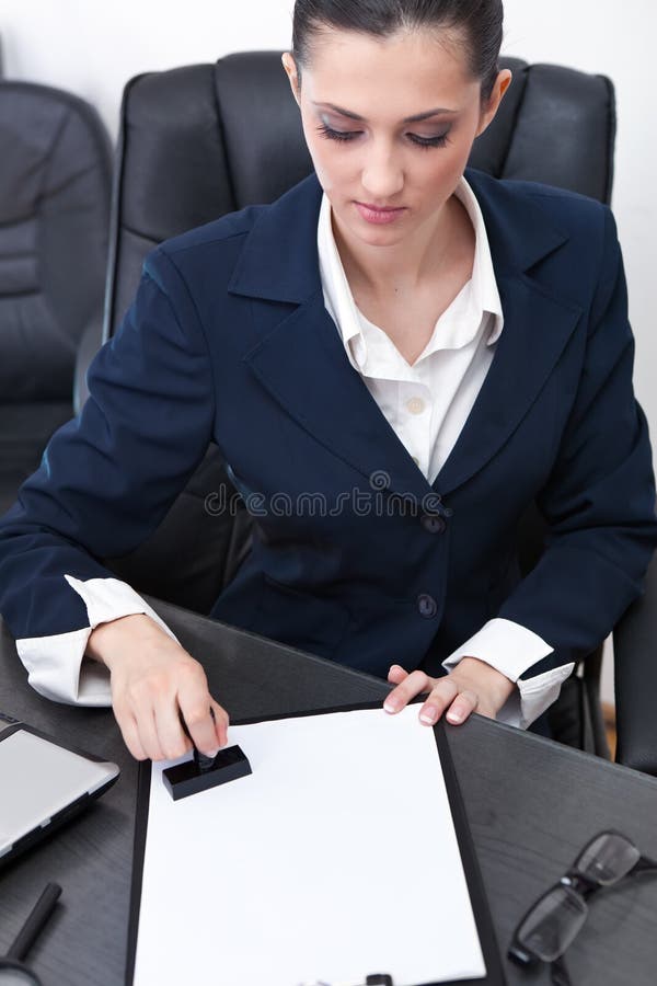 Femme d'affaires estampant des documents photographie stock Femme d'affaires estampant des documents photographie stock