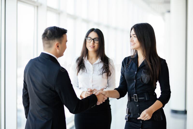 Femme d'affaires d'And d'homme d'affaires se serrant la main dans le bureau lumineux photographie stock libre de droits Femme d'affaires d'And d'homme d'affaires se serrant la main dans le bureau lumineux photographie stock libre de droits