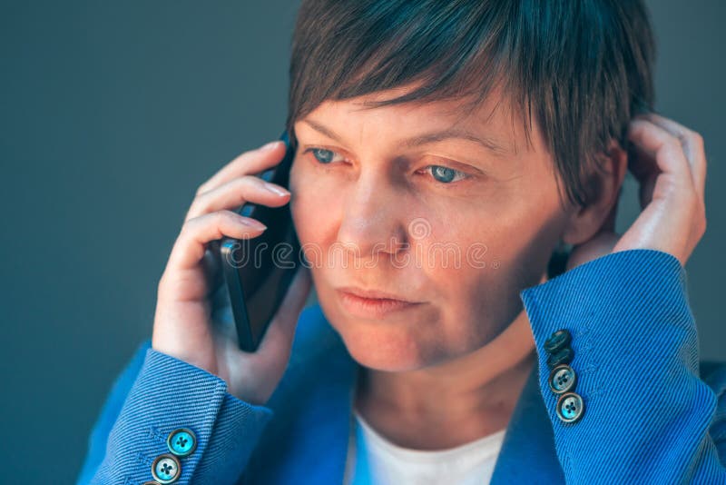 Femme d'affaires inquiétée pendant la conversation téléphonique désagréable photo stock