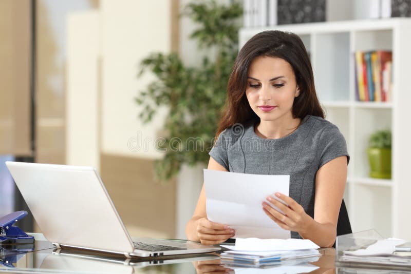 Femme d'affaires lisant une lettre au bureau photographie stock libre de droits Femme d'affaires lisant une lettre au bureau photographie stock libre de droits