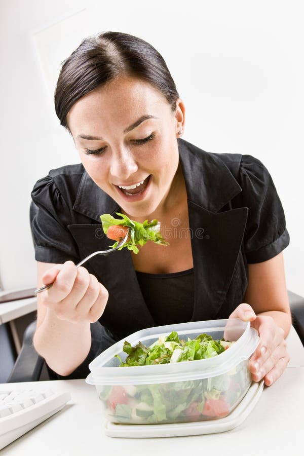 Femme d'affaires mangeant de la salade au bureau photos libres de droits