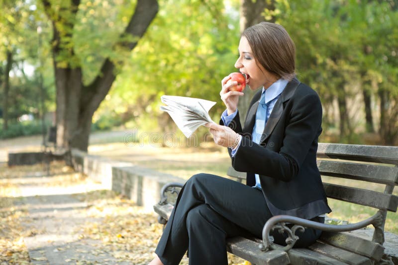 Femme d'affaires mangeant la pomme photographie stock libre de droits