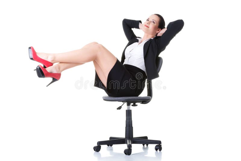 Femme d'affaires s'asseyant sur une chaise avec des jambes. photos stock Femme d'affaires s'asseyant sur une chaise avec des jambes. photos stock