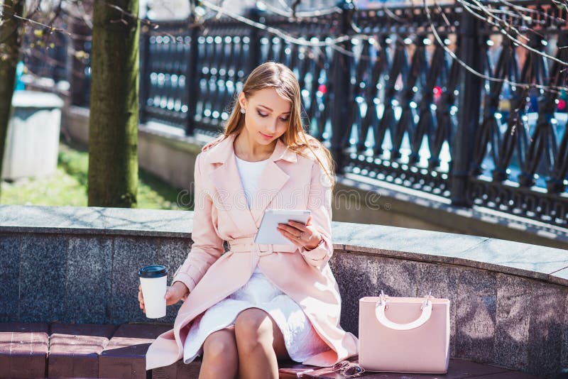 Femme d'affaires sur la rupture en stationnement Jeune femme professionnelle d'affaires à l'aide de la tablette extérieure Modèle photographie stock Femme d'affaires sur la rupture en stationnement Jeune femme professionnelle d'affaires à l'aide de la tablette extérieure Modèle photographie stock