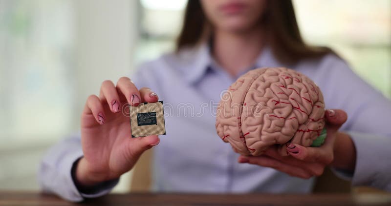 Femme d'affaires tient une petite puce informatique dans le modèle plastique du cerveau humain banque de vidéos