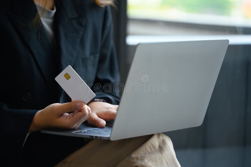 Business woman holding credit card and using laptop making payment or ordering via the internet. Business woman holding credit card and using laptop making payment or ordering via the internet.