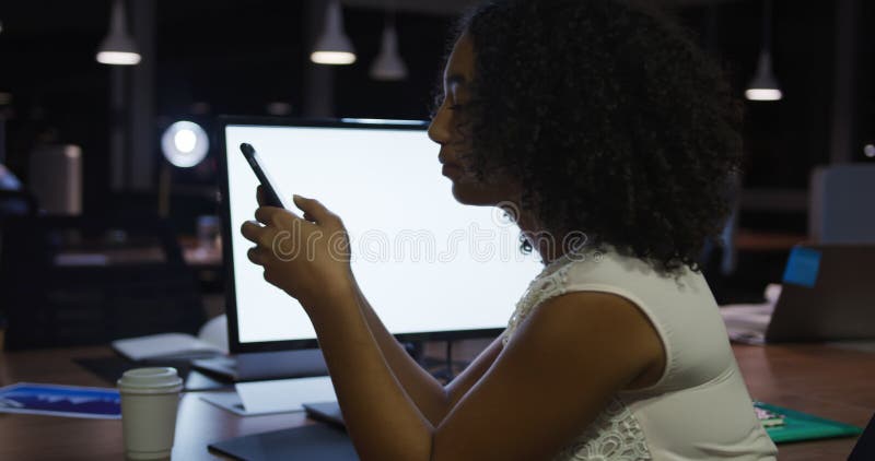 Femme d'affaires travaillant et en utilisant le téléphone dans un bureau moderne par nuit banque de vidéos