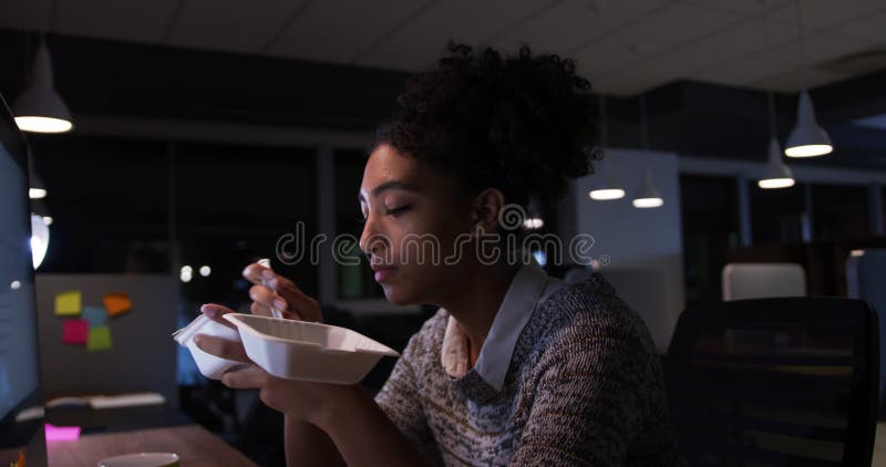 Femme d'affaires travaillant et manger dans un bureau moderne par nuit banque de vidéos
