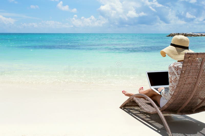Femme d'affaires à l'aide de l'ordinateur portable sur la plage image libre de droits Femme d'affaires à l'aide de l'ordinateur portable sur la plage image libre de droits