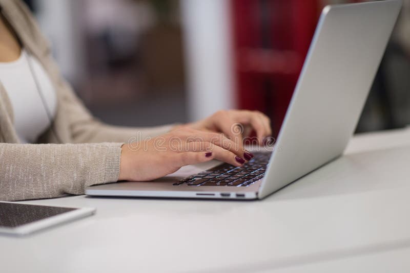 Femme d'affaires à l'aide d'un ordinateur portable dans le bureau de démarrage images libres de droits Femme d'affaires à l'aide d'un ordinateur portable dans le bureau de démarrage images libres de droits