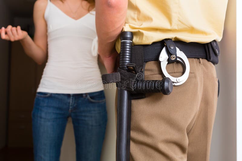 Femme d'interrogation de policier à l'entrée principale images stock Femme d'interrogation de policier à l'entrée principale images stock