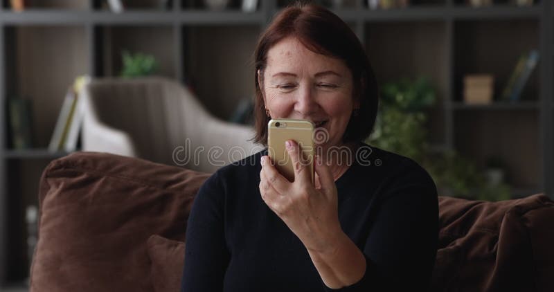 Femme d'âge moyen heureuse tenant un appel vidéo conversation mobile. banque de vidéos