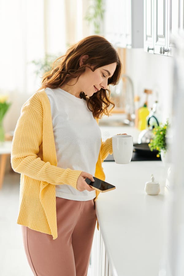 Middle aged woman enjoying a cup of coffee at the kitchen counter, stock photo. Middle aged woman enjoying a cup of coffee at the kitchen counter, stock photo