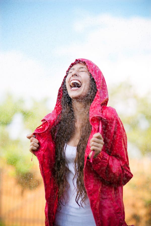Femme dans l'imperméable appréciant la pluie images stock Femme dans l'imperméable appréciant la pluie images stock