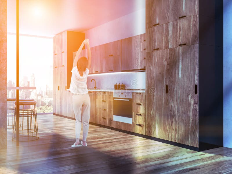 Femme dans l'intérieur en bois foncé de cuisine images libres de droits Femme dans l'intérieur en bois foncé de cuisine images libres de droits