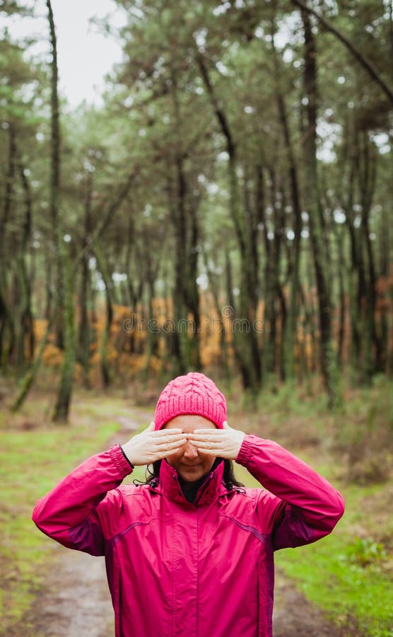 Femme dans la forêt couvrant ses yeux image libre de droits Femme dans la forêt couvrant ses yeux image libre de droits