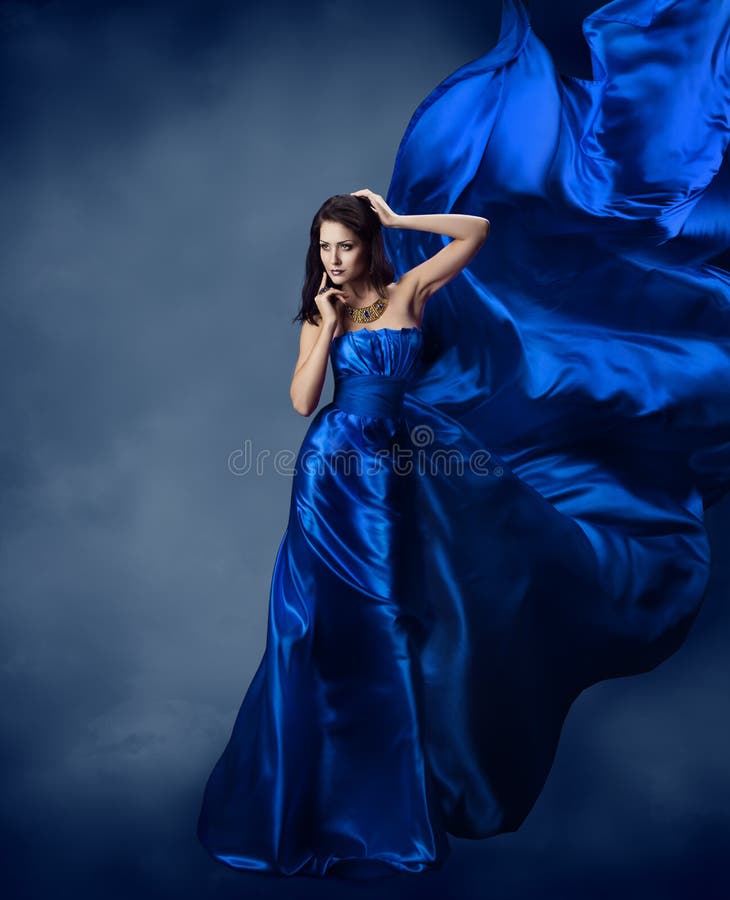Femme dans la robe bleue avec le tissu en soie volant photographie stock