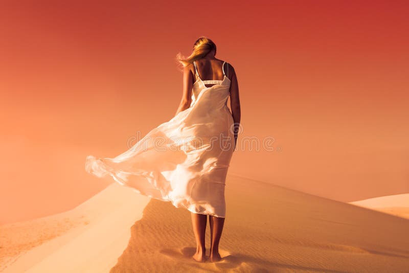 Femme dans la robe de flottement Dunes de désert et de sable Ciel rouge photos libres de droits Femme dans la robe de flottement Dunes de désert et de sable Ciel rouge photos libres de droits
