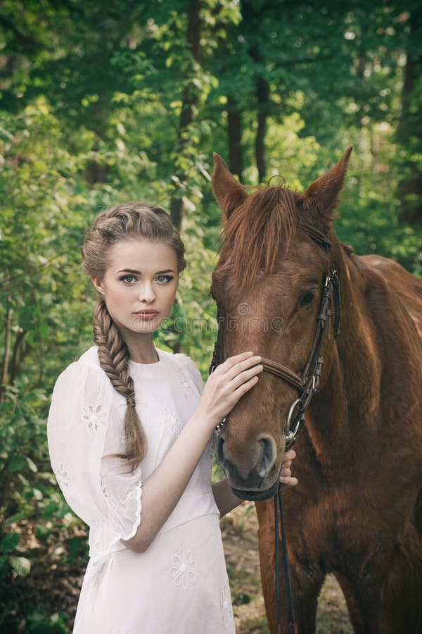 La tête d'un cheval et les mains d'une fille se rapprochent. Elle nourrit  le cheval rouge image libre de droit par WoodHunt © #247683348