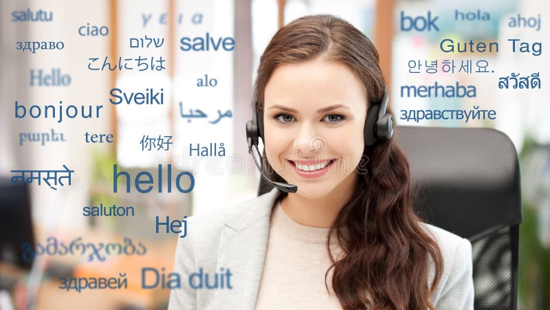 Translation, business and technology concept - smiling female translator or operator in headset at office over greeting words in different foreign languages. Translation, business and technology concept - smiling female translator or operator in headset at office over greeting words in different foreign languages