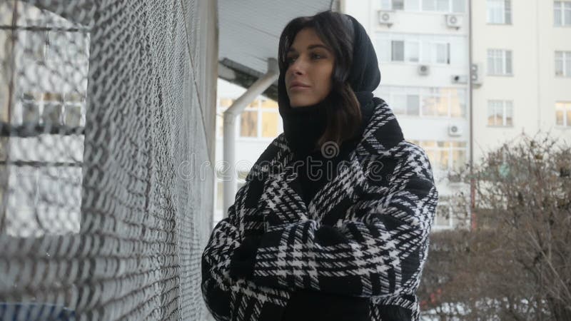 Femme dans le manteau près de la barrière nette clips vidéos