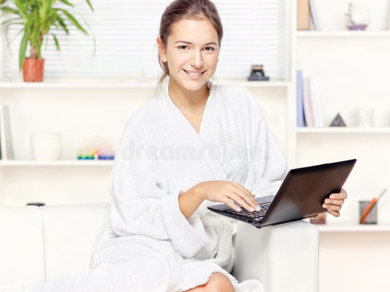 Femme dans le peignoir avec l'ordinateur photographie stock libre de droits Femme dans le peignoir avec l'ordinateur photographie stock libre de droits