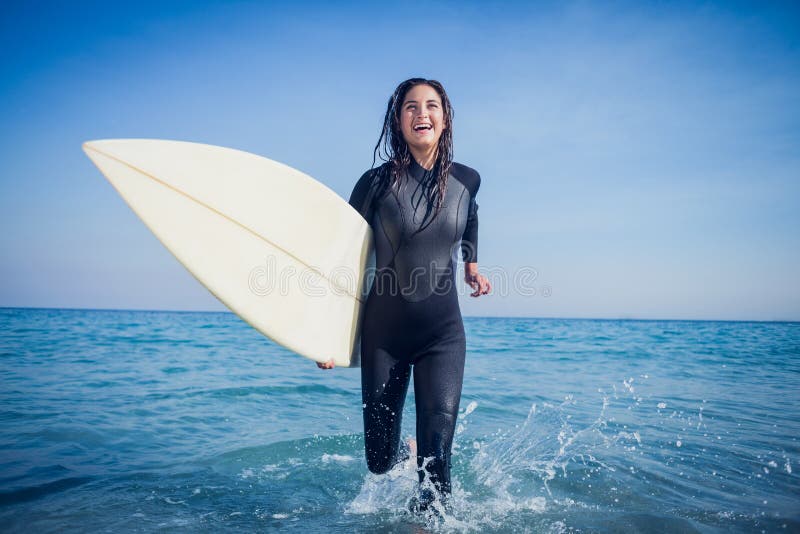 femme dans le wetsuit avec une planche de surf un jour ensoleillé photo stock femme dans le wetsuit avec une planche de surf un jour ensoleillé photo stock