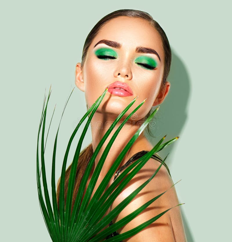Femme de beauté avec la palmette verte naturelle Portrait de la fille modèle avec le maquillage parfait, fards à paupières verts images libres de droits