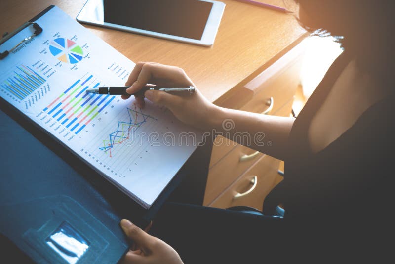 Femme de bureau analysant la fiche technique de ventes pour des affaires d'entreprise images stock Femme de bureau analysant la fiche technique de ventes pour des affaires d'entreprise images stock