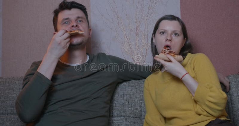 Femme de couples et pizza mangeuse d'hommes à la maison et regarder un film. Au moment de loisirs de quarantaine clips vidéos