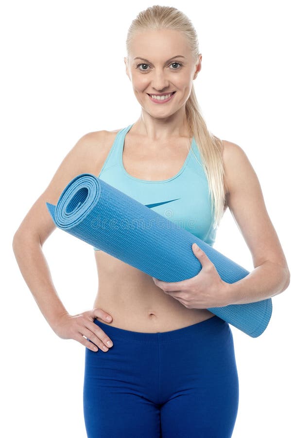Femme de forme physique avec un tapis d'exercice photo libre de droits Femme de forme physique avec un tapis d'exercice photo libre de droits