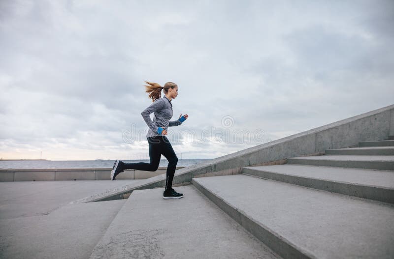 Femme de forme physique courant sur des étapes photo libre de droits Femme de forme physique courant sur des étapes photo libre de droits