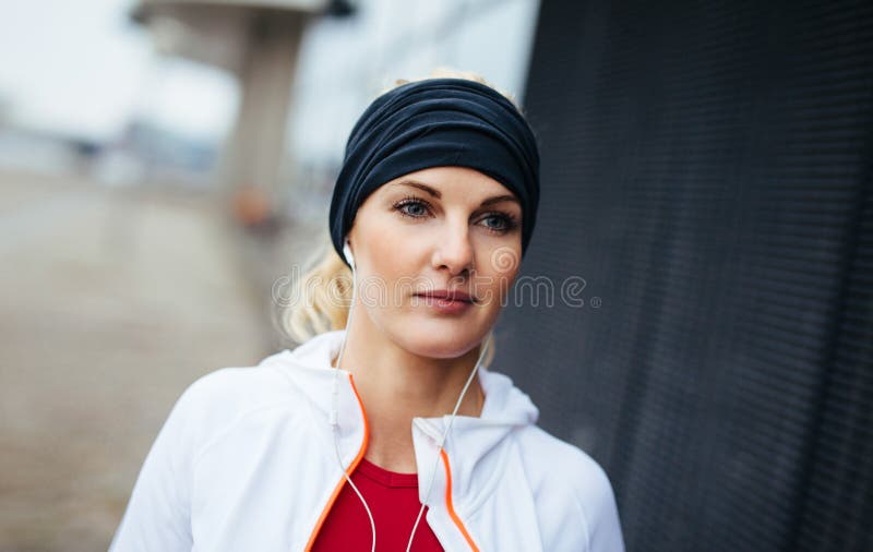Femme de forme physique semblant décontractée dehors images libres de droits Femme de forme physique semblant décontractée dehors images libres de droits