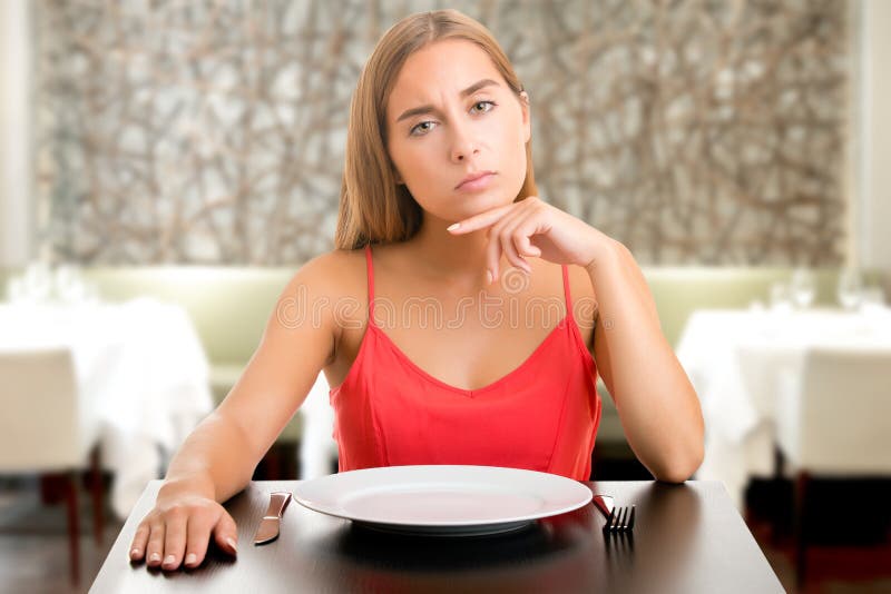 Femme de Hungy attendant avec un plat vide images stock Femme de Hungy attendant avec un plat vide images stock