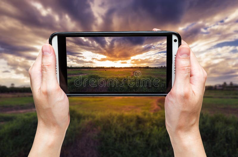 Femme de main prenant la photo au coucher du soleil photo stock Femme de main prenant la photo au coucher du soleil photo stock