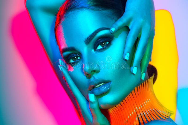 Femme de mannequin dans les lumières lumineuses colorées avec le maquillage et la manucure à la mode photos stock Femme de mannequin dans les lumières lumineuses colorées avec le maquillage et la manucure à la mode photos stock