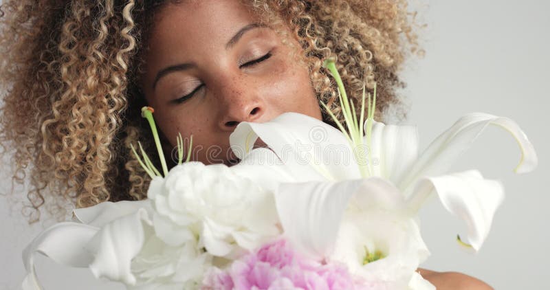 Femme de métis de beauté dans le studio avec des fleurs clips vidéos