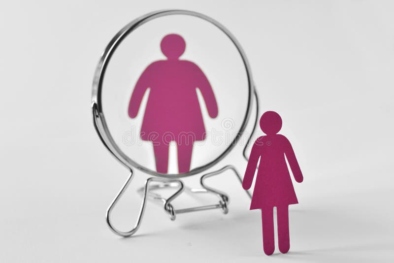 Femme de papier mince regardant dans le miroir et se voyant en tant que grosse femme - anorexie et concept de troubles de la nutr images libres de droits Femme de papier mince regardant dans le miroir et se voyant en tant que grosse femme - anorexie et concept de troubles de la nutr images libres de droits