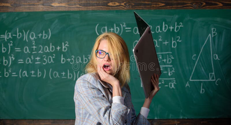Femme de professeur soulevant l'ordinateur portable au-dessus d'elle-même prêt à détruire Surmenage du système nerveux Conditions photos stock Femme de professeur soulevant l'ordinateur portable au-dessus d'elle-même prêt à détruire Surmenage du système nerveux Conditions photos stock