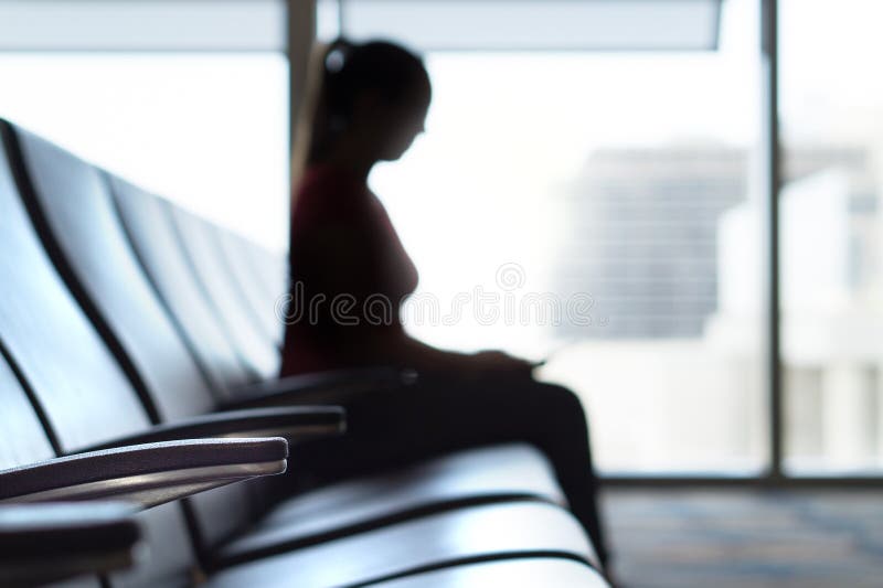Femme de silhouette dans la salle d'attente d'aéroport photographie stock Femme de silhouette dans la salle d'attente d'aéroport photographie stock