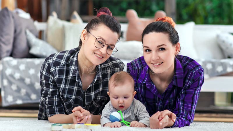Femme de sourire assez occasionnelle de deux couples et peu d'enfant mignon posant regardant la caméra clips vidéos