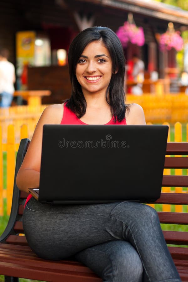 Femme de sourire avec l'ordinateur portatif