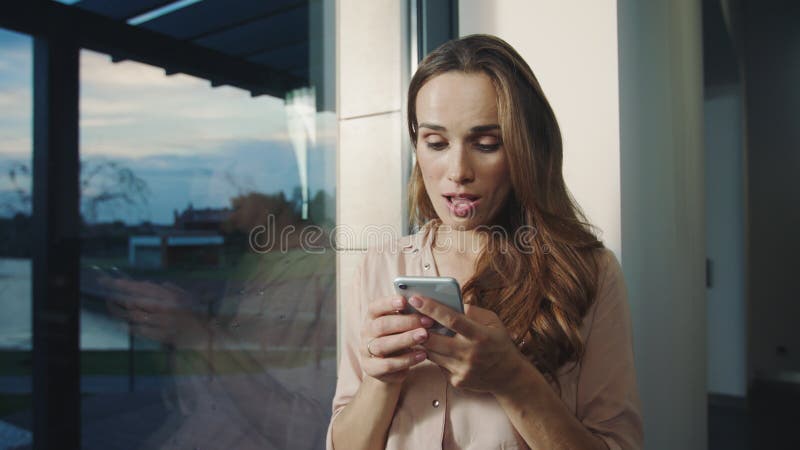 Femme de sourire causant sur le téléphone portable Portrait de femme heureuse envoyant le message