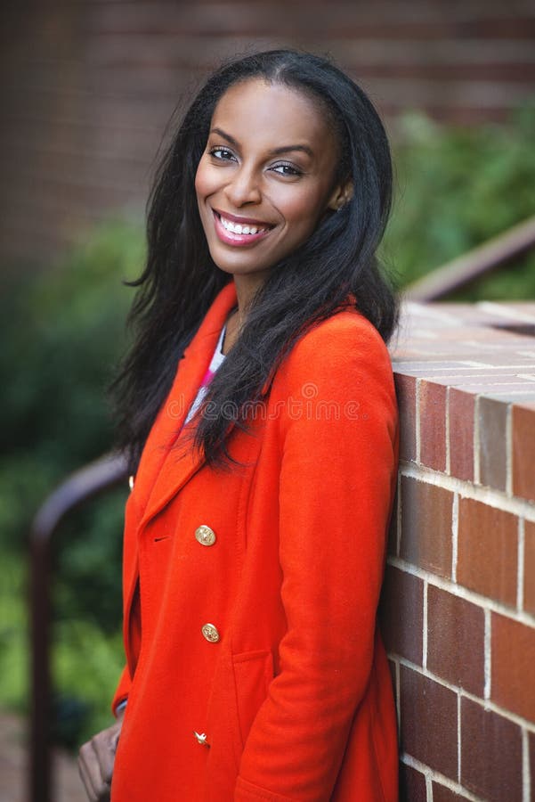 Femme de sourire d'affaires de jeune afro-américain se tenant dehors images libres de droits Femme de sourire d'affaires de jeune afro-américain se tenant dehors images libres de droits