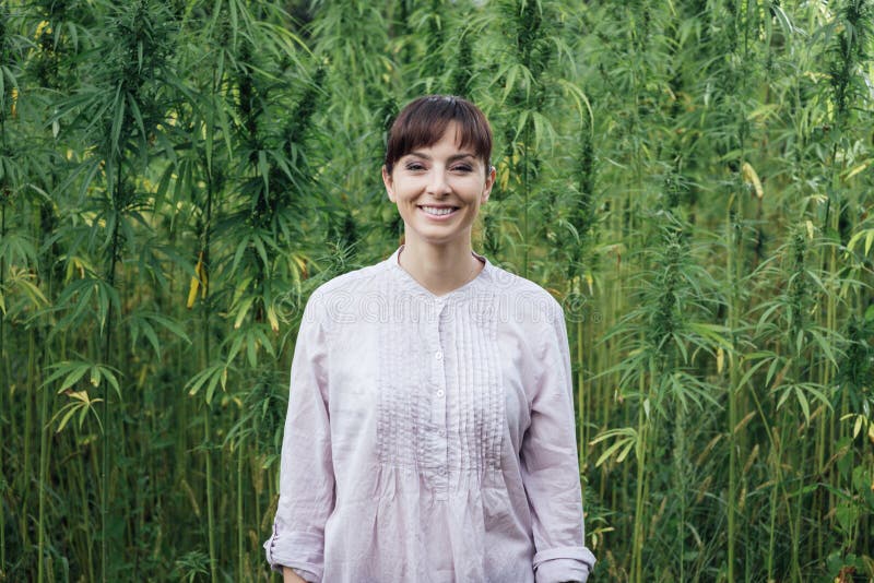 Femme de sourire dans le domaine de chanvre photographie stock libre de droits Femme de sourire dans le domaine de chanvre photographie stock libre de droits