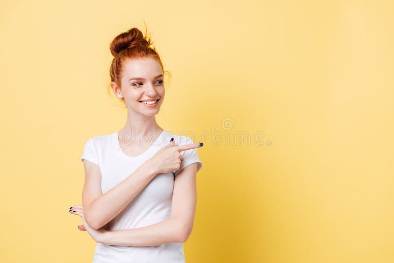 Femme de sourire de gingembre dans le T-shirt se dirigeant et regardant loin photographie stock libre de droits Femme de sourire de gingembre dans le T-shirt se dirigeant et regardant loin photographie stock libre de droits