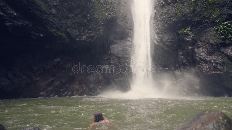 Femme de sourire se baignant dans le lac de montagne sur la cascade débordante de fond dans apprécier heureux de femme de forêt t