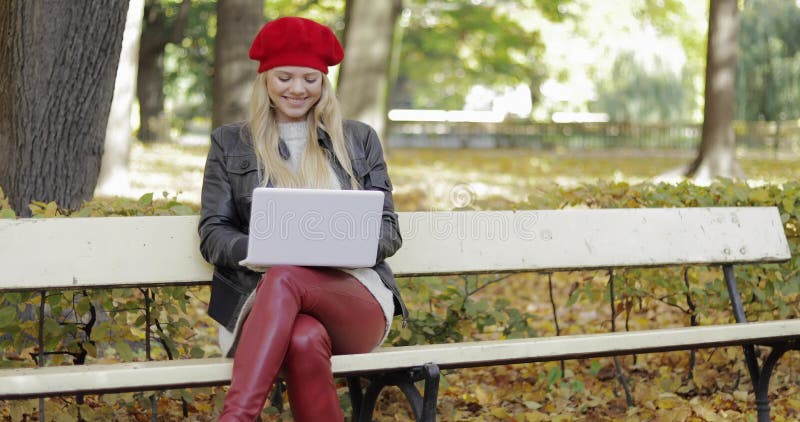 Femme de sourire à l'aide de l'ordinateur portable dans le parc clips vidéos
